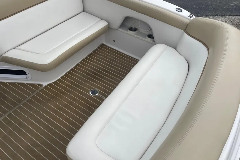 Slide: The Image of 2009 Four Winns V258 boat interior with beige and white seating, wooden flooring. - 12