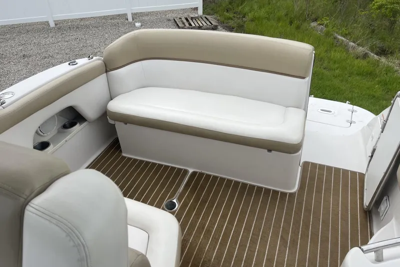 Slide: The Image of 2009 Four Winns V258 boat interior with beige and white seating, striped flooring. - 13