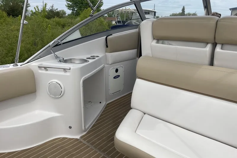 Slide: The Image of 2009 Four Winns V258 boat interior with beige and white seating, sink, and speaker. - 14