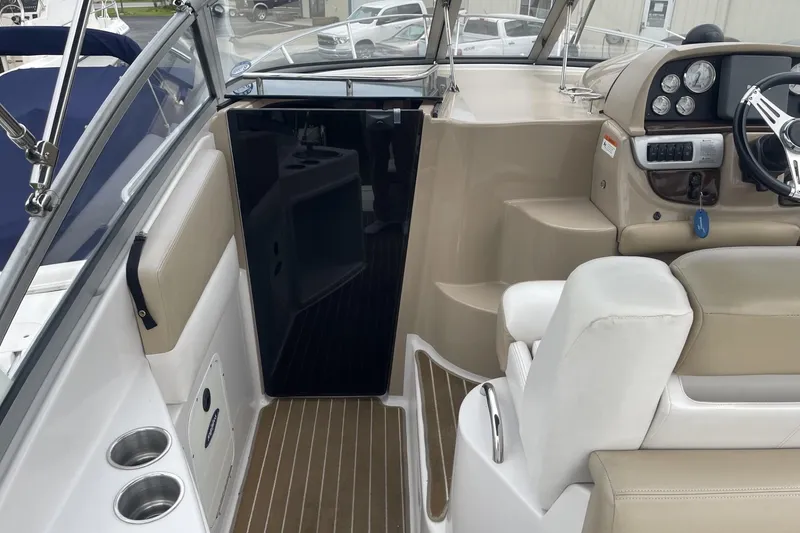 Slide: The Image of 2009 Four Winns V258 boat interior with steering wheel and seating area. - 15
