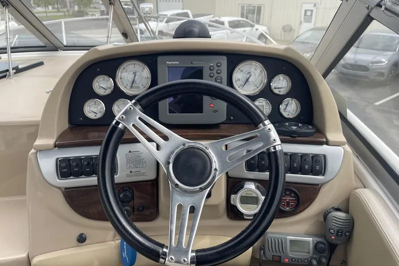 Slide: The Image of 2009 Four Winns V258 boat dashboard with steering wheel and navigation instruments. - 19
