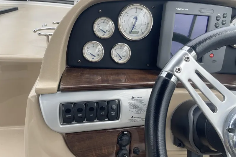 Slide: The Image of 2009 Four Winns V258 dashboard with gauges, switches, and steering wheel. - 20