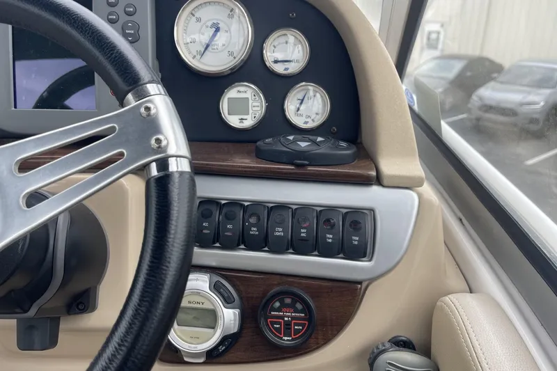 Slide: The Image of 2009 Four Winns V258 boat dashboard with steering wheel and control gauges. - 23