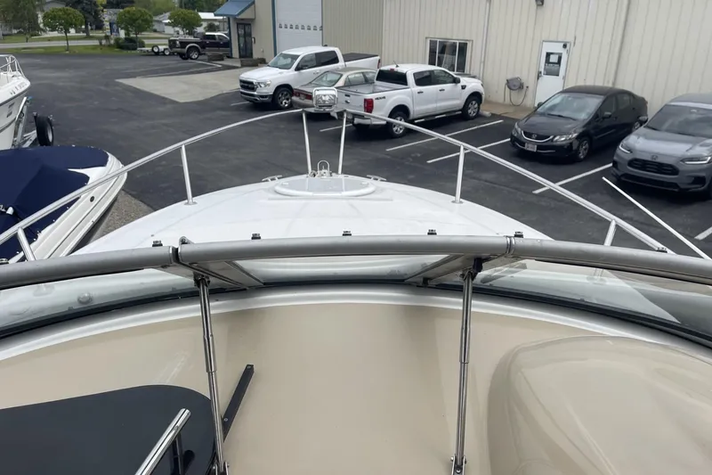 Slide: The Image of 2009 Four Winns V258 boat docked near parked vehicles and a building. - 26