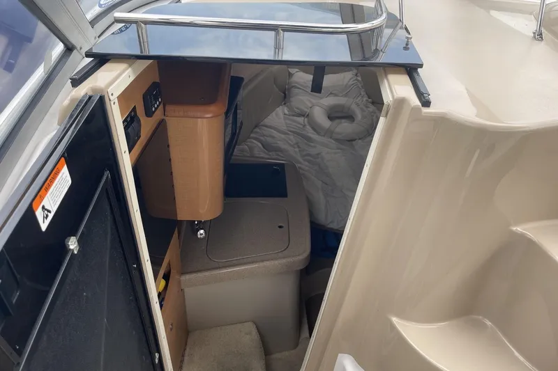 Slide: The Image of Interior cabin of 2009 Four Winns V258 boat, featuring compact sleeping area and storage. - 28