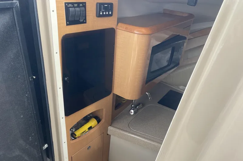 Slide: The Image of 2009 Four Winns V258 cabin interior with kitchenette and control panel. - 29