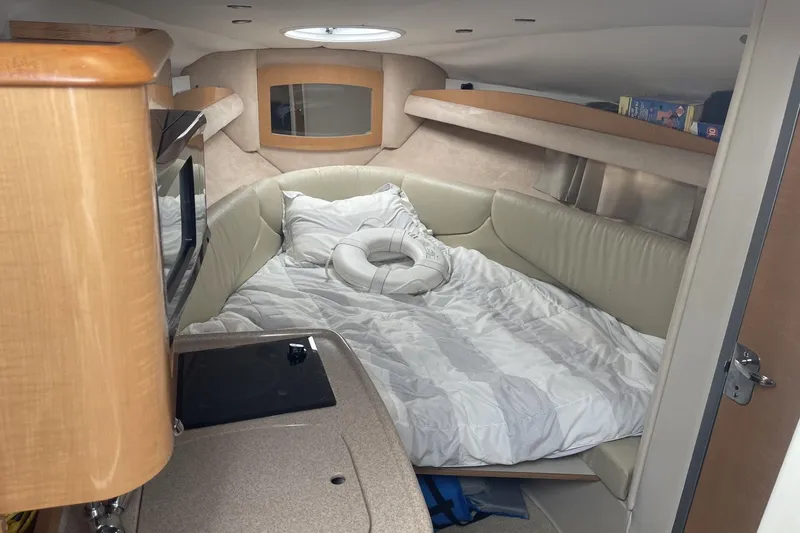 Slide: The Image of 2009 Four Winns V258 cabin interior with cozy bed and compact kitchen area. - 32