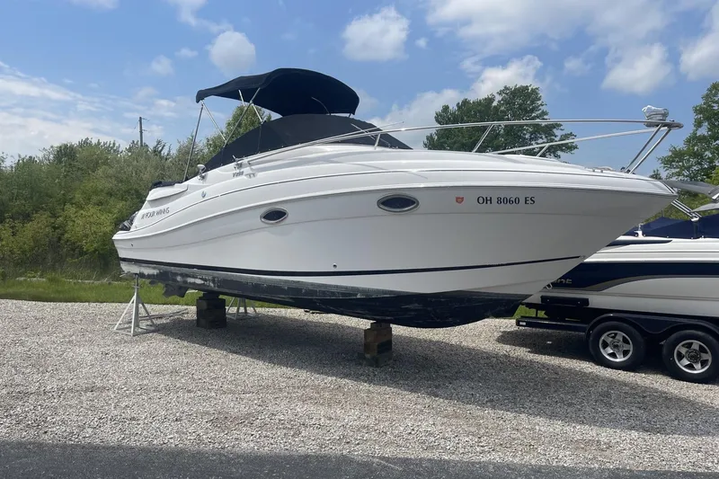 Slide: The Image of 2009 Four Winns V258 boat on stands, white exterior, parked outdoors. - 44