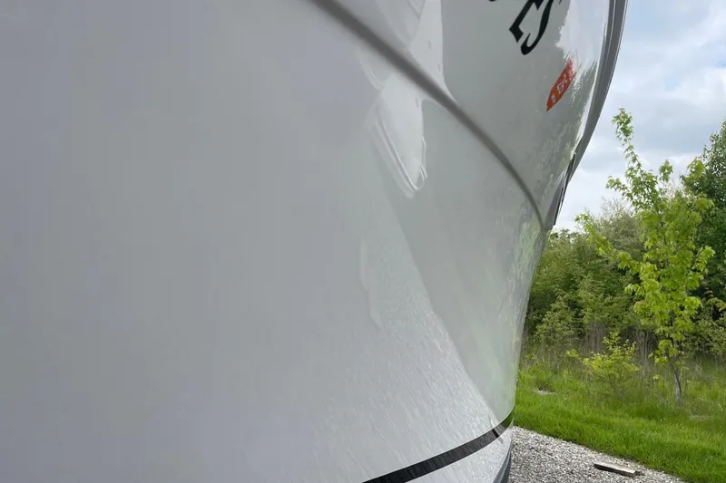 Slide: The Image of Close-up of 2009 Four Winns V258 boat hull with greenery in the background. - 6