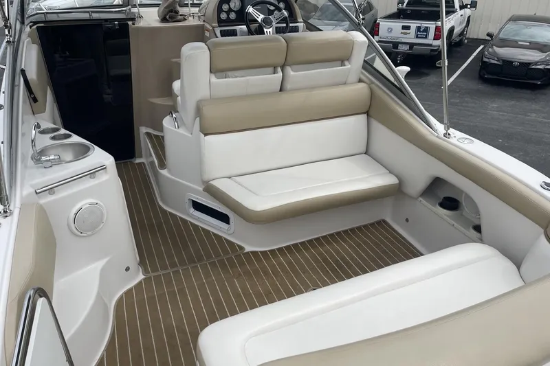 Slide: The Image of 2009 Four Winns V258 boat interior with beige and white seating, steering wheel, and cup holders. - 8
