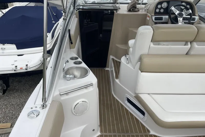 Slide: The Image of 2009 Four Winns V258 boat interior with seating, steering wheel, and sink. - 9