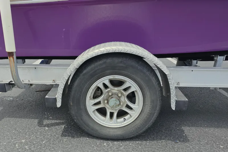 Slide: The Image of Trailer wheel of a 2016 Aqua Dyne 17 boat with purple hull. - 13