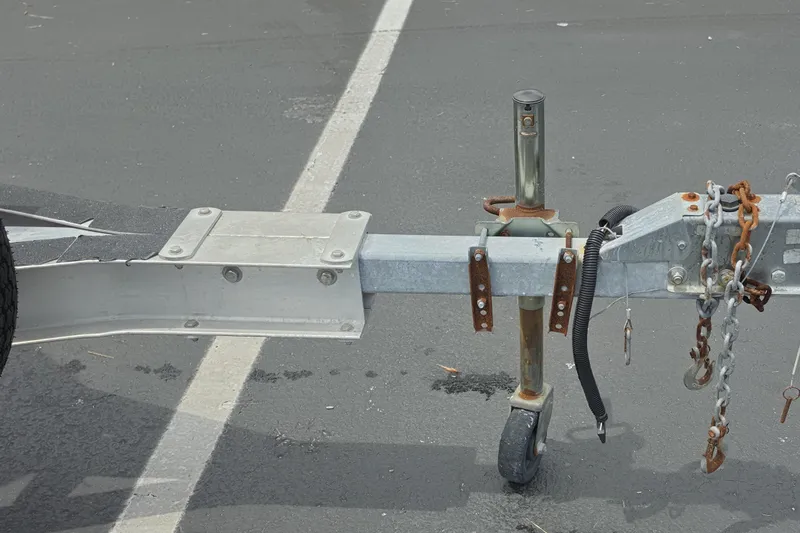 Slide: The Image of Trailer hitch of a 2016 Aqua Dyne 17 with chains and wheel on asphalt. - 17