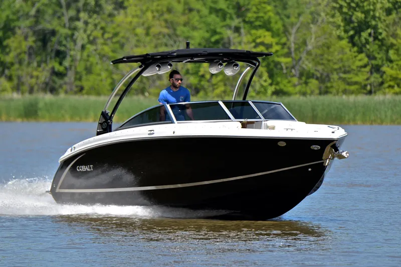 The Image of 2018 Cobalt R7 boat cruising on a lake with lush green background. - 1