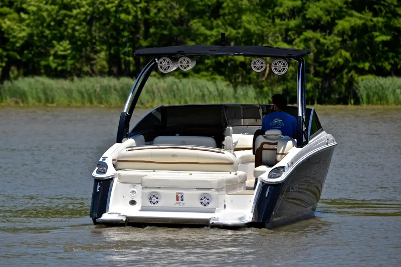 Slide: The Image of 2018 Cobalt R7 boat cruising on a calm lake with lush green trees. - 10