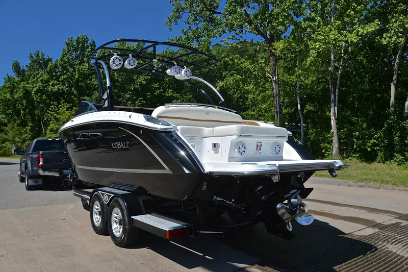 Slide: The Image of 2018 Cobalt R7 boat on trailer, parked near lush green trees. - 13