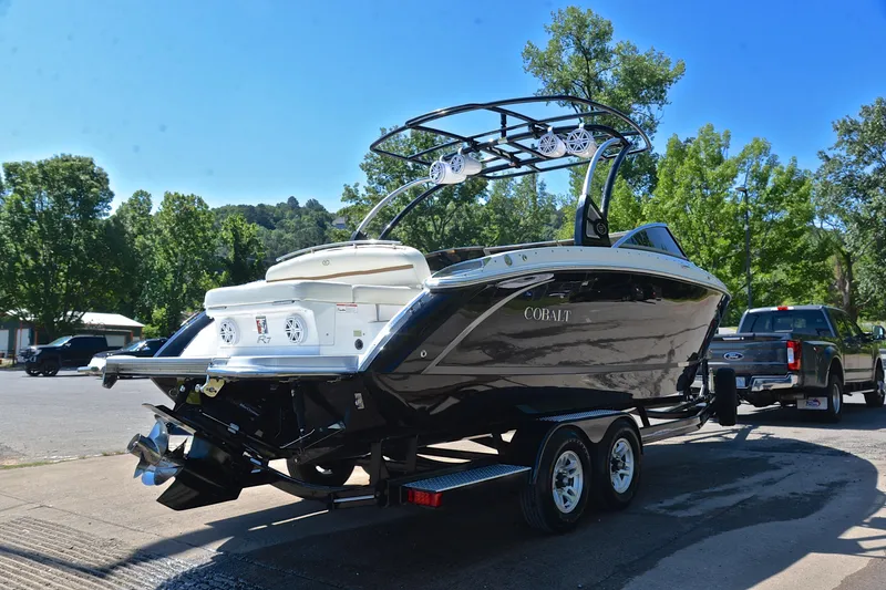 Slide: The Image of 2018 Cobalt R7 boat on trailer, parked outdoors with trees in background. - 15