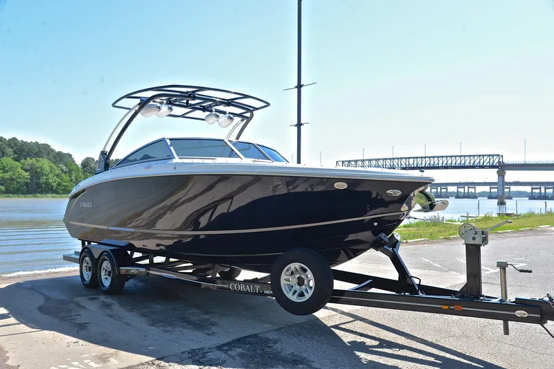 Slide: The Image of 2018 Cobalt R7 boat on trailer by riverside with bridge in background. - 17