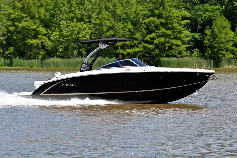 Slide: The Image of 2018 Cobalt R7 boat cruising on a lake with lush green trees in the background. - 3