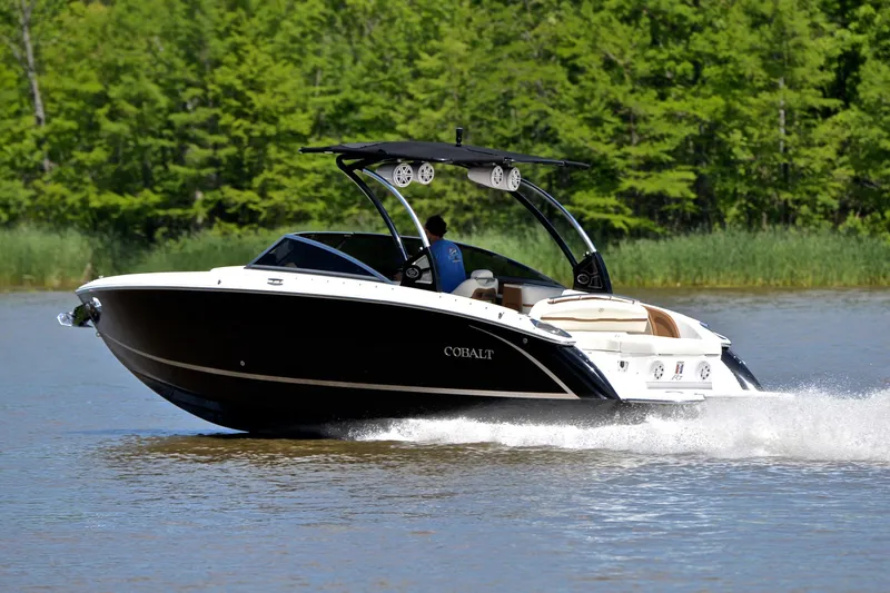 Slide: The Image of 2018 Cobalt R7 boat cruising on a lake with lush green trees in the background. - 4