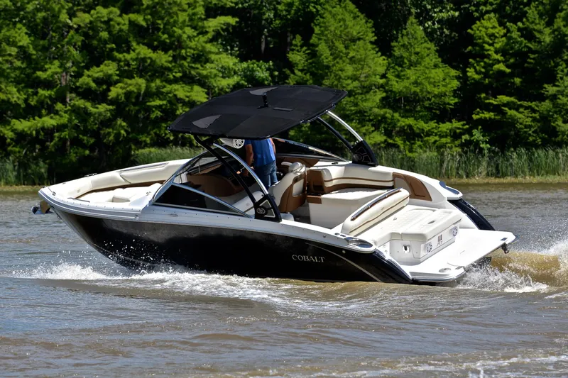 Slide: The Image of 2018 Cobalt R7 boat cruising on a lake with lush green trees. - 7