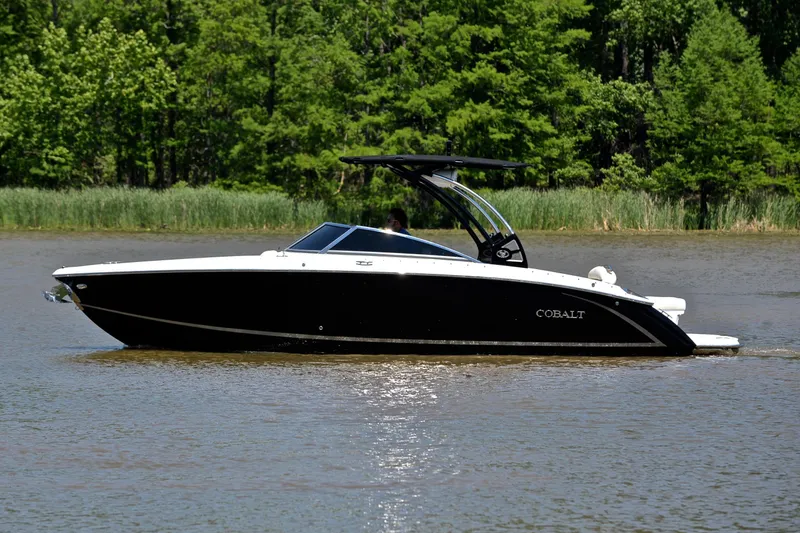 Slide: The Image of 2018 Cobalt R7 boat cruising on a calm lake with lush green trees. - 9