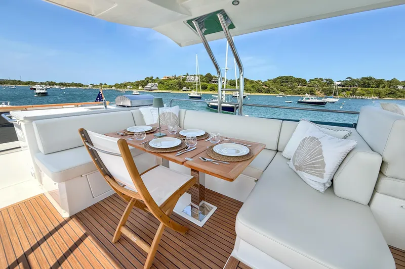 Slide: The Image of Luxurious dining area on 2026 Beneteau Swift Trawler 54, overlooking serene waters and anchored boats. - 18