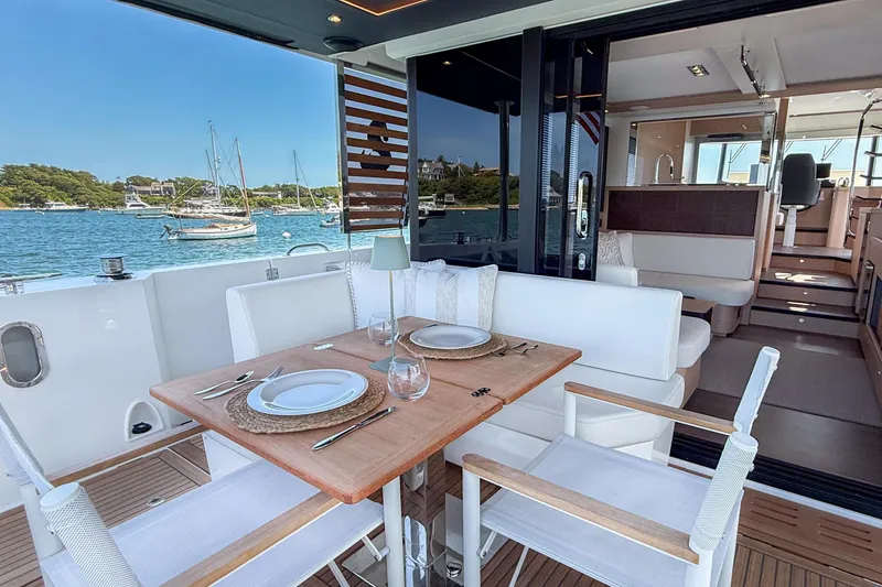 Slide: The Image of Luxurious dining area on 2026 Beneteau Swift Trawler 54 yacht, overlooking serene waters. - 19