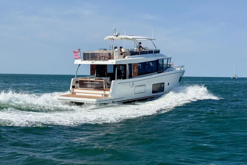 Slide: The Image of 2026 Beneteau Swift Trawler 54 cruising on open sea with American flag. - 30