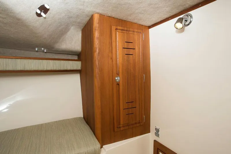 Slide: The Image of Manufacturer Provided Image: 2018 Albemarle 25 Express cabin interior with wooden storage cabinet and bed. - 26