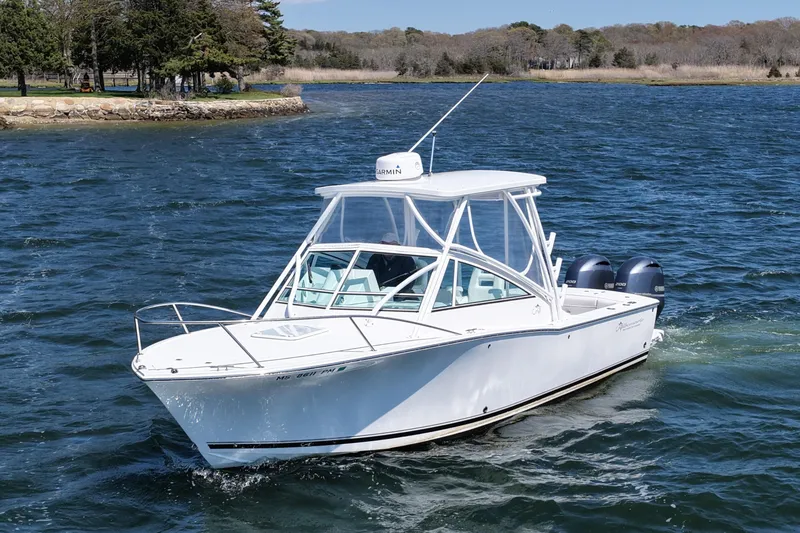 Slide: The Image of 2018 Albemarle 25 Express boat cruising on a scenic lake with lush shoreline. - 6