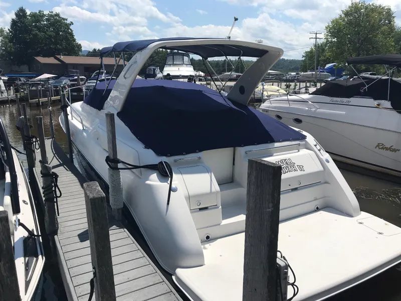 Slide: The Image of 1999 Regal 322 Commodore boat docked at a marina under a clear sky. - 2
