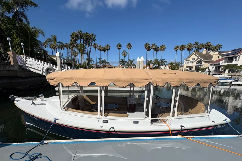The Image of 2019 Duffy Cuddy Cabin 22 boat docked in a scenic marina setting. - 0