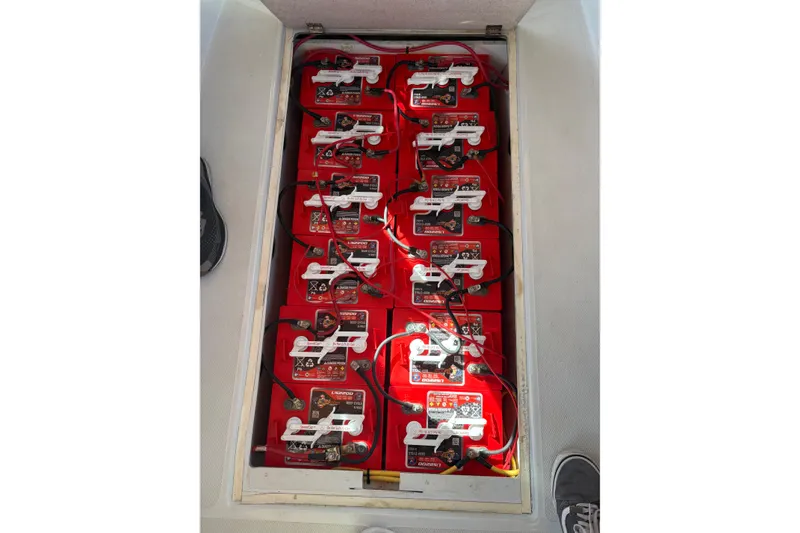 Slide: The Image of Battery compartment of 2019 Duffy Cuddy Cabin 22, featuring multiple red batteries. - 17