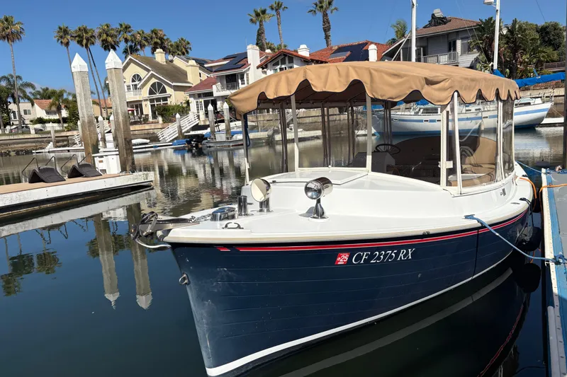 Slide: The Image of 2019 Duffy Cuddy Cabin 22 docked in a sunny marina setting. - 2