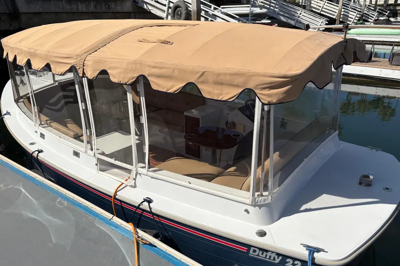 Slide: The Image of 2019 Duffy Cuddy Cabin 22 boat with beige canopy docked at marina. - 3