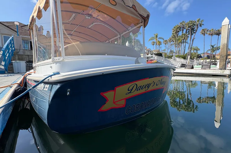 Slide: The Image of 2019 Duffy Cuddy Cabin 22 boat docked in sunny marina with palm trees. - 4