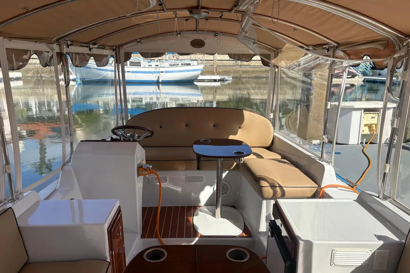 Slide: The Image of 2019 Duffy Cuddy Cabin 22 interior with seating and table, docked at marina. - 6