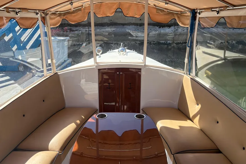 Slide: The Image of Interior of 2019 Duffy Cuddy Cabin 22 boat with tan seating and wooden table. - 9