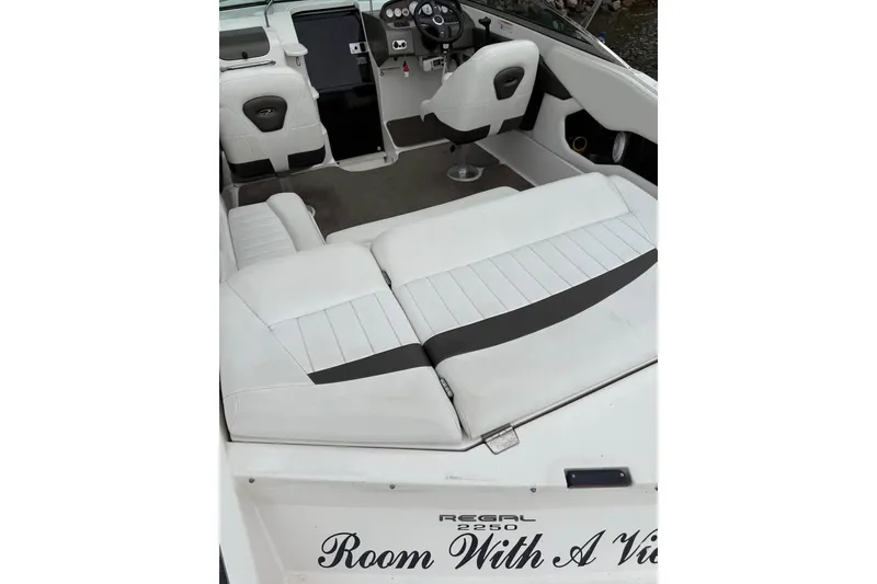 Slide: The Image of 2008 Regal 2250 Cuddy boat interior with white seating and steering console. - 12