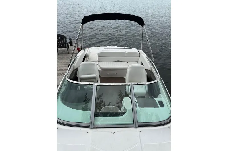 Slide: The Image of 2008 Regal 2250 Cuddy boat with white interior, docked by a lake. - 15