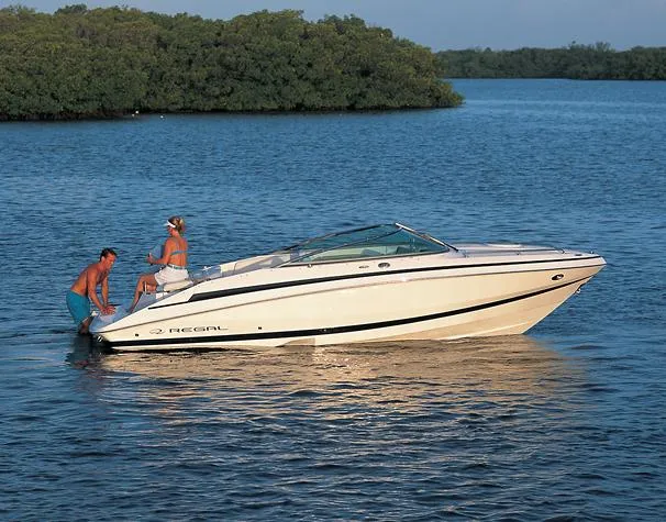 Slide: The Image of 2008 Regal 2250 Cuddy boat on calm water with two people. - 8