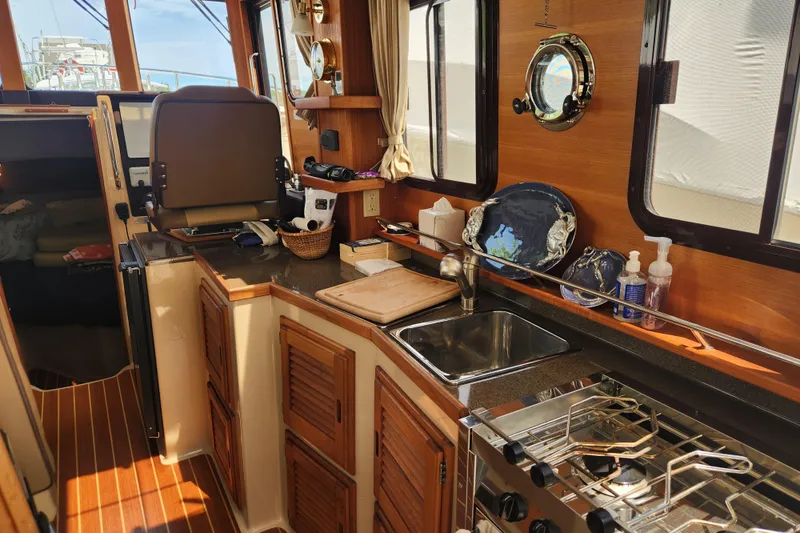 Slide: The Image of Interior of 2019 Ranger Tugs R-31 CB boat featuring a compact kitchen area. - 13