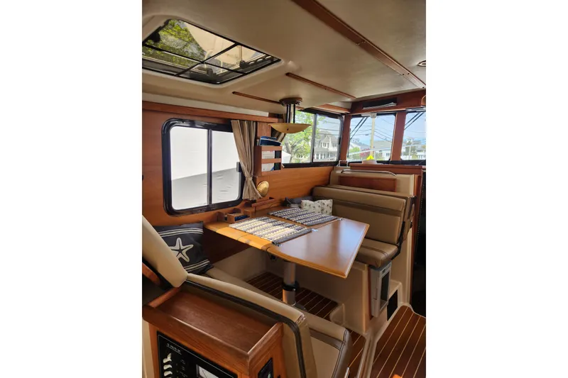Slide: The Image of Interior of 2019 Ranger Tugs R-31 CB with cozy seating and wooden accents. - 15