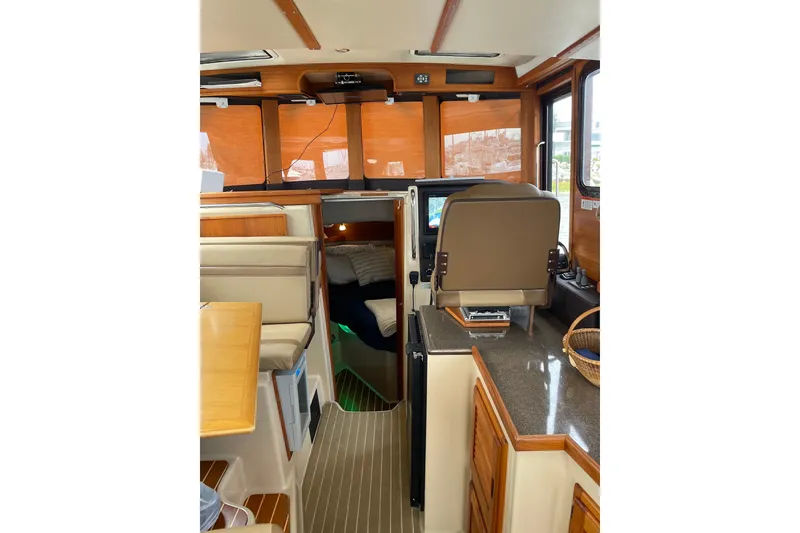 Slide: The Image of Interior of 2019 Ranger Tugs R-31 CB, featuring helm, seating, and cabin area. - 16