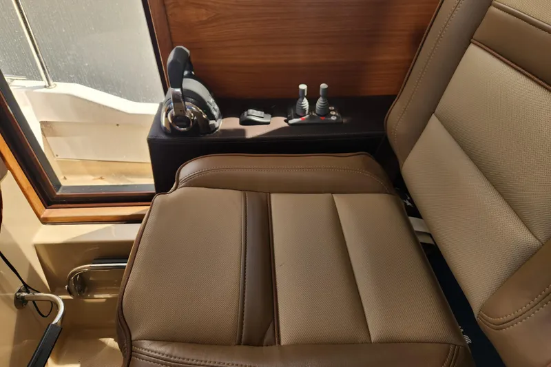 Slide: The Image of 2019 Ranger Tugs R-31 CB interior with brown leather seat and control panel. - 17