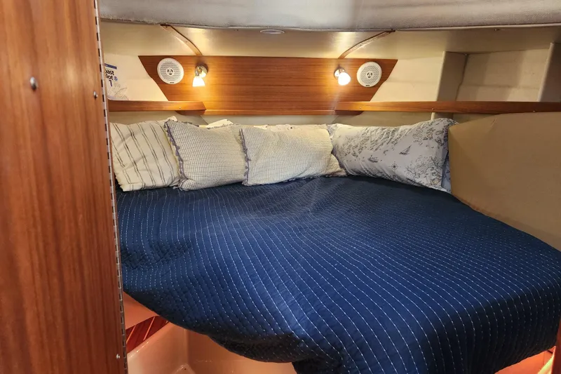 Slide: The Image of Cozy cabin interior of 2019 Ranger Tugs R-31 CB with blue bedding and ambient lighting. - 19