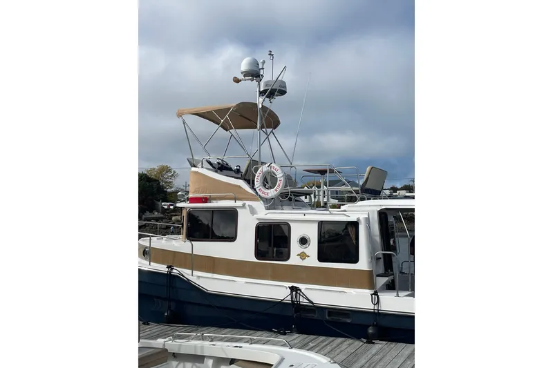 Slide: The Image of 2019 Ranger Tugs R-31 CB boat docked, featuring upper deck and navigation equipment. - 2