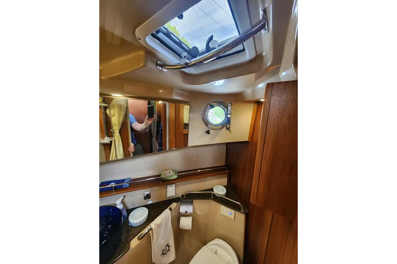 Slide: The Image of 2019 Ranger Tugs R-31 CB bathroom with skylight, mirror, and wooden accents. - 22
