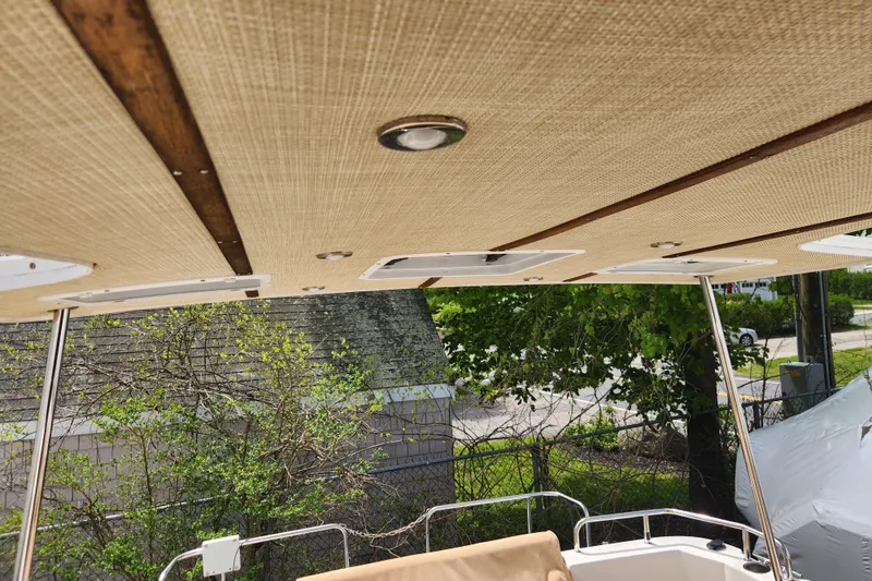Slide: The Image of 2019 Ranger Tugs R-31 CB boat canopy with wooden accents and outdoor view. - 29